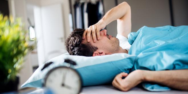 a man waking up, still tired, after not sleeping well