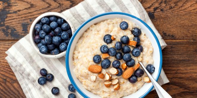 a bowl of coconut porridge with almonds and blueberries