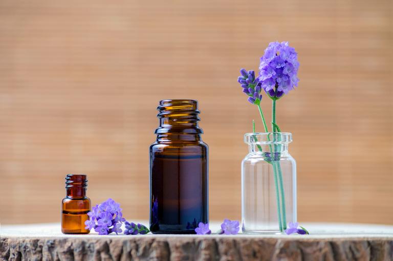 Lavender essential oil bottles and fresh flowers for aromatherapy.