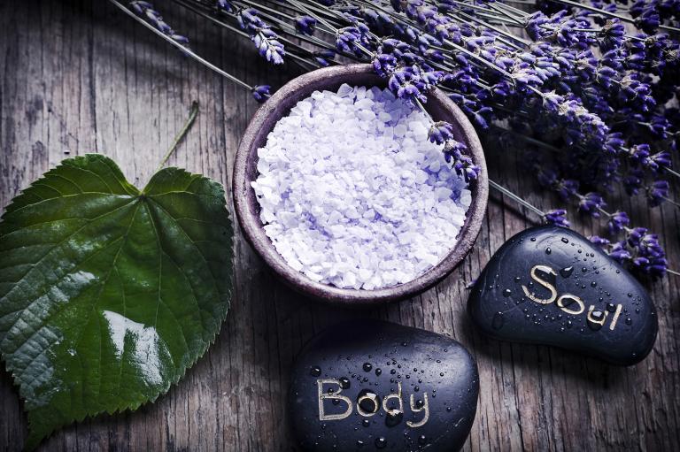 A green leaf with healing stones, a bowl with lavender herb salt and dry French lavender.