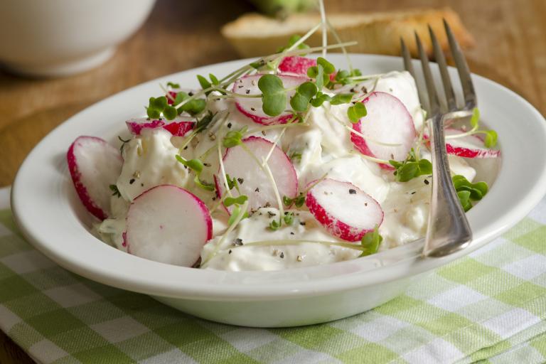 a bowl of potato salad with sliced radish