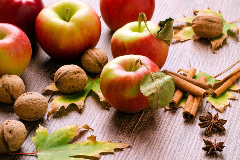 fresh apples, walnuts in the shell, and sticks of cinnamon