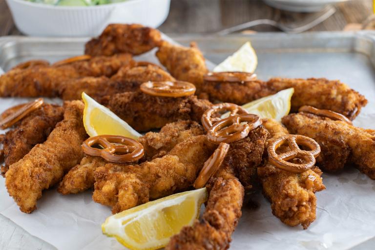 a plate of baked chicken breaded with pretzels